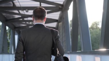 Takım elbiseli bir ofis çalışanı gün ışığında yürür. Sokaktaki iş adamı bir iş toplantısına gider. Ağır çekim. Yavaş çekim