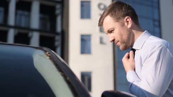 ビジネスマンは彼の車の窓の外を見て 通りにネクタイをつけます 時間外の男だ 会議に遅れて — ストック動画