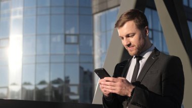 Genç patron yeni bir galibiyet davasını dört gözle bekliyor. İş adamı akıllı telefona bakar ve sevinir. İş adamları konsepti