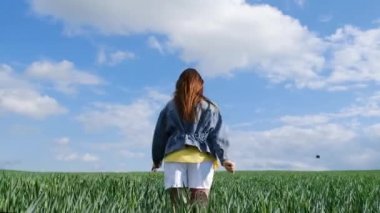 Yaz günü aile yürüyüşü, arkadaş canlısı aile kavramı. Çocuklar ve mutlu ebeveynler yeşil bir tarlanın ortasında yürürler. Mutlu bir aile.