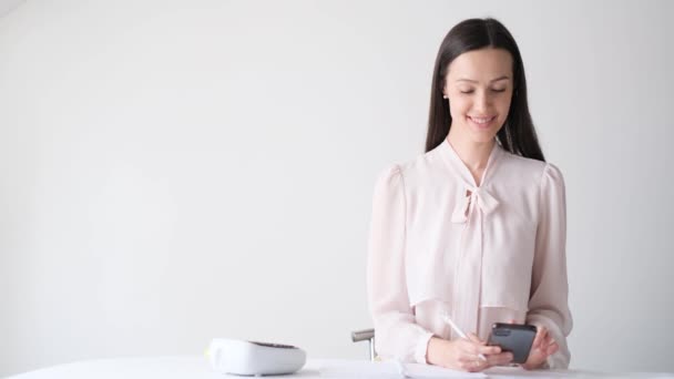 Zakenvrouw Werkt Het Kantoor Met Een Smartphone Een Glimlach Een — Stockvideo