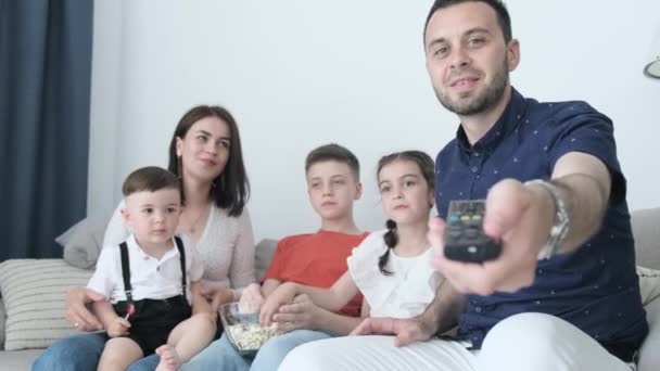 Χαρούμενη Οικογένεια Βλέποντας Τηλεόραση Κάθεται Στον Καναπέ Γελάνε Και Χορεύουν — Αρχείο Βίντεο