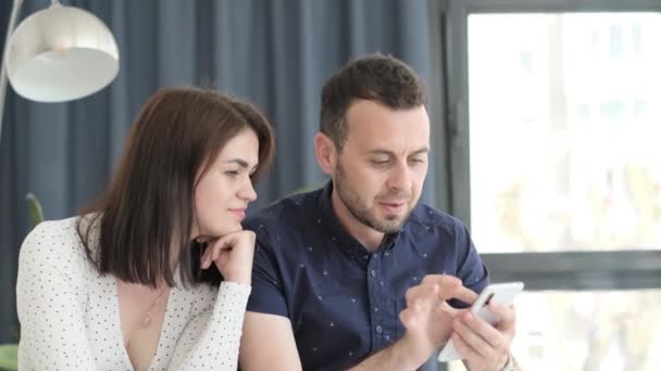 Szczęśliwa Para Relaksująca Się Kanapie Domu Mąż Trzymający Smartfona Rękach — Wideo stockowe