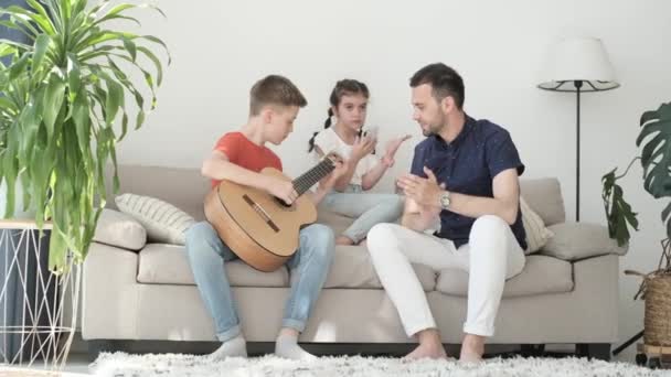 Sonen Spelar Gitarr Fadern Och Systern Lyssnar Melodin Tonårspojke Som — Stockvideo