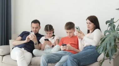 Avrupa neslinin ailesi teknolojiyi, modern akıllı telefonları ve evdeki oturma odasındaki kanepede birlikte eğlenmeyi seviyor..