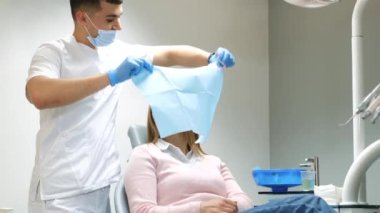 Korkak kız modern bir klinikte dişlerini tedavi ediyor. Korkaklık ve diş hekimi korkusu. Diş hekimi hastaların dişlerini muayene eder.