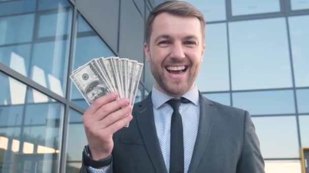 Portret Uśmiechniętego Odnoszącego Sukcesy Mężczyzny Garniturze Wskazującego Palcem Stos Banknotów — Wideo stockowe