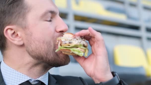 Joven Hombre Negocios Hambriento Comiendo Deliciosamente Una Hamburguesa — Vídeo de stock