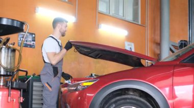 Araba tamirhanesinde çalışan Amerikalı bir tamirci. Elektrikli araçların onarımı ve bakımı. 4k video