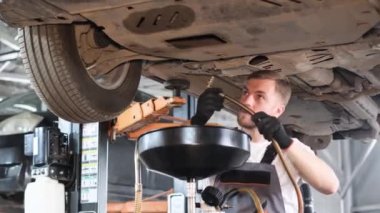 Araç bakımı, araba tamircisi motordaki yağı değiştiriyor. Modern araba servisi. 4k video