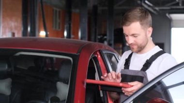 Amerikalı bir tamirci, bilgisayar kontrolleri, araba, motor ve tel pillerin tamiri için modern ekipman yardımıyla aracı korur..