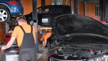 Arabanın klima kompresöründeki benzini doldurmak için manometresi olan araba tamircisi. Benzin istasyonu. Araba tamiri.