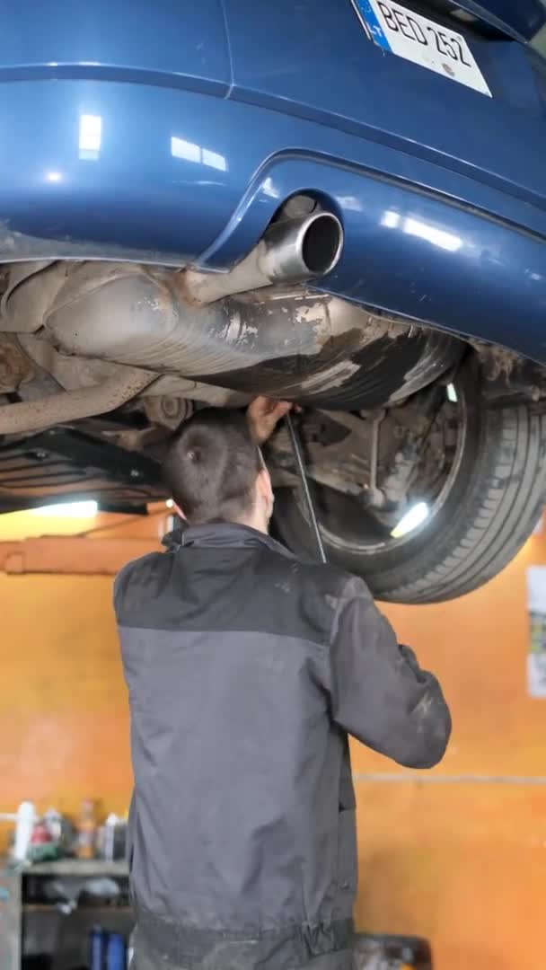 在垂直录像中 一位机械师检查了汽车的运行系统 穿制服的工人 有缺陷的车 汽车服务 — 图库视频影像