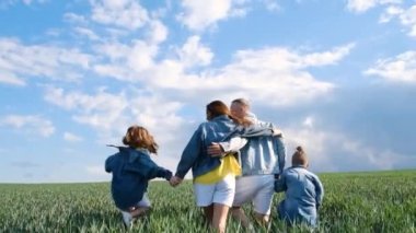 Buğday tarlasının ortasında çok mutlu bir aile kucaklaşır. Birlikte mutluyuz. Denim ailesi bakışı