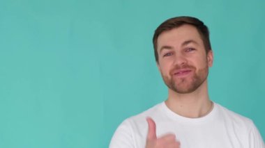 Yakışıklı erkek fotokopi için parmağını boş yere doğrultuyor. Stüdyoda izole edilmiş bir arka plan. Adam davayı öneriyor, dikkatinizi veriyor, video reklam amaçlı.