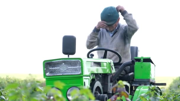 Grandpa Puts Hat While Sitting Tractor Village Worker His Garden — Stockvideo
