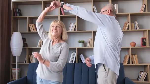 Senioren Paar Tanzt Hause Wohnzimmer Sie Lachen Und Umarmen Sich — Stockvideo