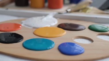 Close up of a professional artist mixing a palette of paints for painting. Creativity concept. 4k video