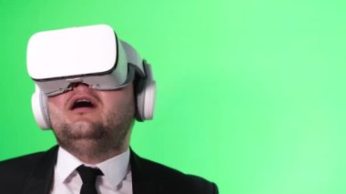 Avrupalı işadamı krom anahtarın arka planında sanal gerçeklik gözlüğü takıyor ve kullanıyor. Gelecekteki iş konsepti.