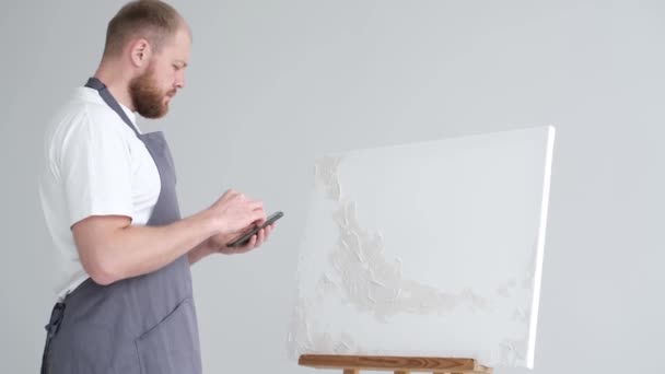 Καλλιτέχνης Εφαρμόζει Μια Γύψινη Βάση Λευκό Καμβά Καλλιτέχνης Εργάζεται Στο — Αρχείο Βίντεο