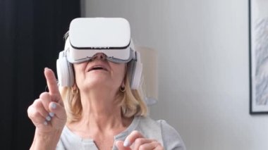 An old grandmother relaxes in virtual reality glasses. A modern vision of the future
