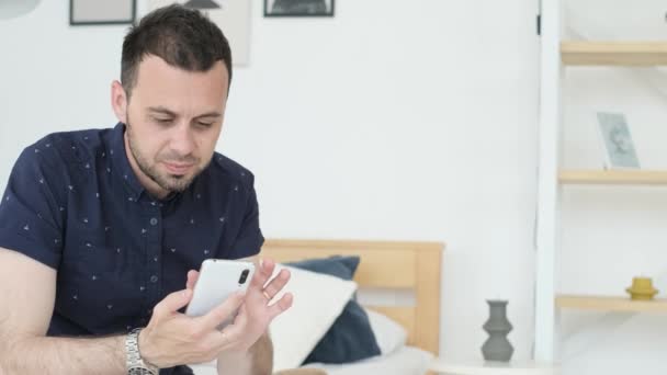 Young Man Blue Shirt Sitting Sofa Living Room Looking Information — 图库视频影像