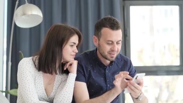 Young Man His Wife Sitting Sofa Living Room Looking Phone — Video