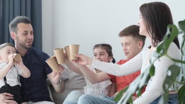 Happy Mom Dad Three Children Sitting Couch Holding Glasses Drinking — Stock video