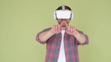 Handsome man in virtual reality glasses studio on yellow and green background. Modern virtual reality technologies