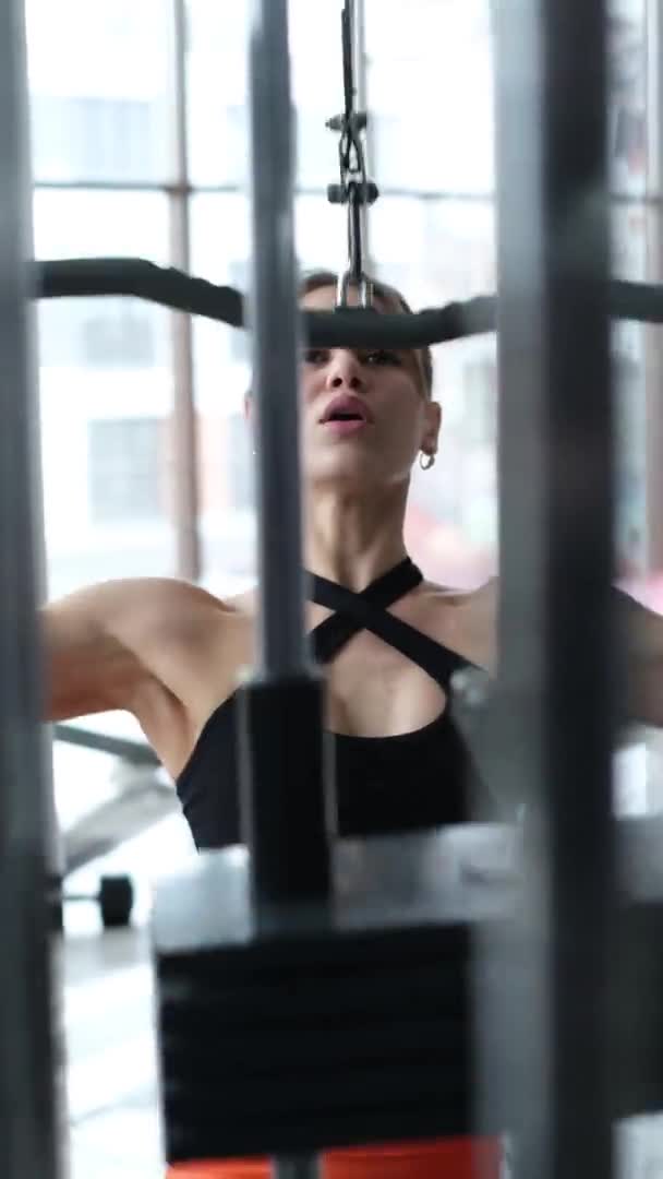 Vídeo Vertical Mulher Treina Músculos Das Costas Ginásio Ela Bombeia — Vídeo de Stock