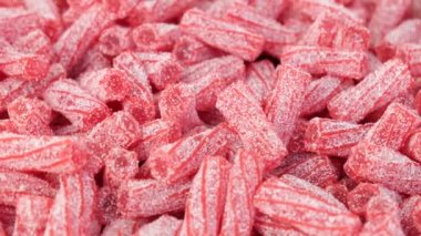 Red marmalade lies on the counter of a candy store. Dark red marmalade in white sugar. Chopped homemade marmalade sprinkled with sugar. The concept of sweets