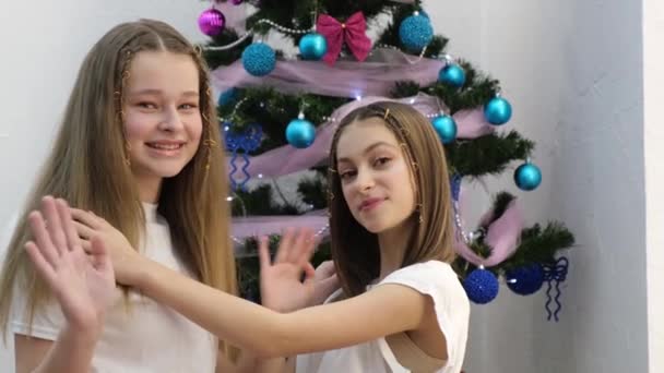 Two Sisters Christmas Tree Waving Hello Having Fun New Years — Stockvideo