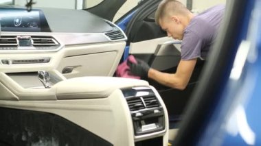A man cleaning car door handle with cloth. Car detailing. 