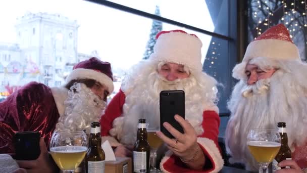 Чоловіки Костюмах Санта Клауса Дивляться Свої Смартфони Спілкуються Один Одним — стокове відео