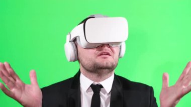 Man in a business suit with virtual reality glasses on a background of chromakey. Office worker, manager
