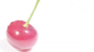 Red juicy cherry with fruit stalks on a white background, delicious and ripe fruit. Video macro shooting