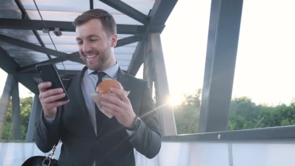 Portrait Handsome Young Man Suit Using Smartphone Eating Hamburger Manager — Vídeo de Stock