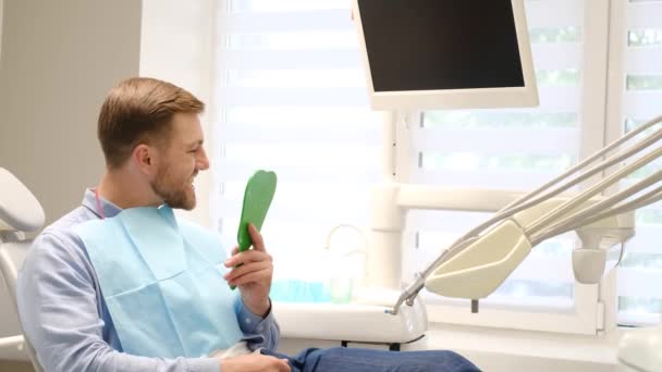 Ικανοποιημένος Ασθενής Κοιτάζει Στον Καθρέφτη Αποτέλεσμα Της Οδοντιατρικής Θεραπείας Ανώδυνη — Αρχείο Βίντεο