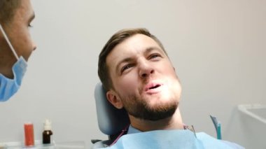 Cheerful young patient of European appearance during a visit to the dentist. The key to healthy teeth