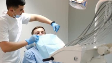 Young handsome patient before dental treatment in the dental office. Modern technologies in dentistry