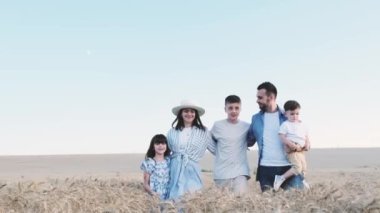 Family photo session in nature. A happy European family with three children is walking through a wheat field. A walk in the summerto go