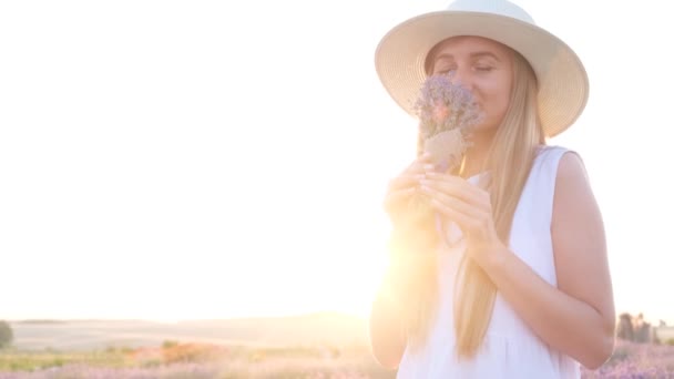 Приваблива Жінка Стоїть Під Яскравим Сонячним Світлом Нюхає Лавандові Квіти — стокове відео