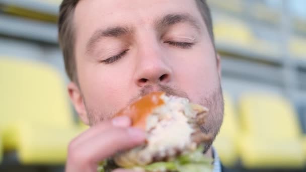 Крупный План Портрета Молодого Человека Поедающего Вкусный Бургер Наслаждаюсь Едой — стоковое видео