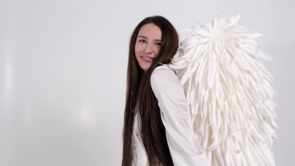 天使をイメージした笑顔の女性の肖像画 白い背景に長いストレートの髪の女の子 バレンタインデーのコンセプト スローモーション — ストック動画