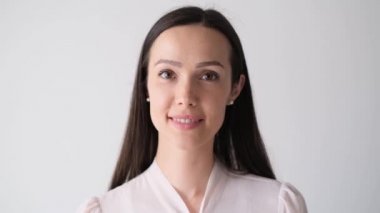 Güzel bir iş kadınının portresi, kameraya bakıyor ve gülüyor. Kendine güvenen genç Avrupalı bir kadın, güzel bir yüz, ofiste tek başına poz veriyor, profesyonel, yakın plan.