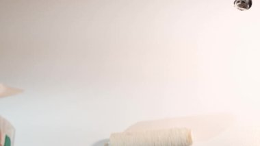 Çalışırken duvarı silindirle boyayan profesyonel bir inşaatçı. Modern tamirat, odanın duvarlarını boyamak.