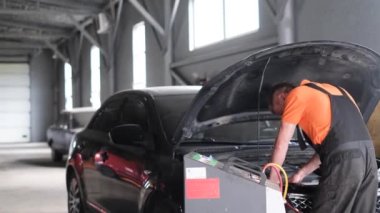 Bir araba tamircisi bir benzin istasyonunda bir araba klimasını tamir eder. Araba havalandırma denetleme servisi. Soğutma şarj sistemi. Araba servisi.