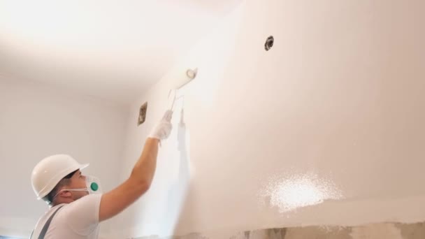 Pracownik Budowlany Białym Hełmie Maluje Ścianę Biało Malowanie Naprawa Lokalu — Wideo stockowe