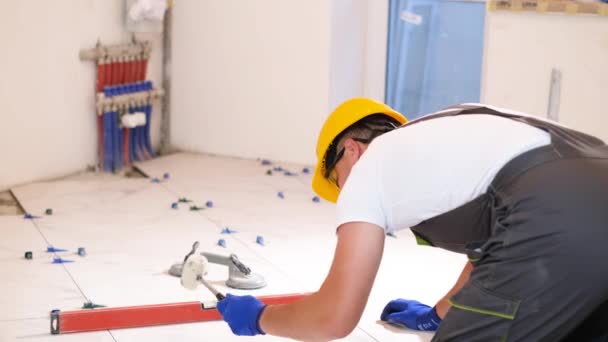 Een Vakman Overalls Installeert Tegels Vloer Reparaties Het Huis Bouw — Stockvideo