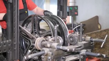 Oto tamircisi araba jantlarını hizalar. Stynium disklerin yuvarlanması ve dengelenmesi için lastik uydurma makinesi. Araba servisi.